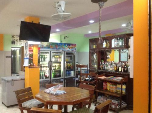 um restaurante com mesa e um bar com bebidas em Bambus Motel em Praia de Jomtien