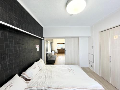 a bedroom with a bed with a black accent wall at K-ART Stay Shinsakae2 in Nagoya