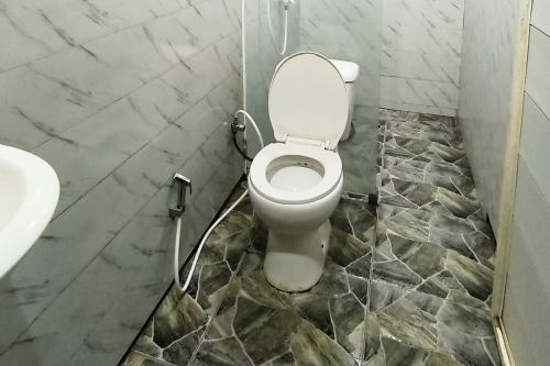 a bathroom with a toilet and a sink at Spekta Merbabu powered by Cocotel in Jlarem