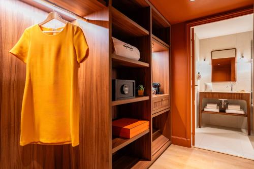 a yellow shirt is hanging on a closet in a bathroom at Hôtel Lepoussin in Cannes