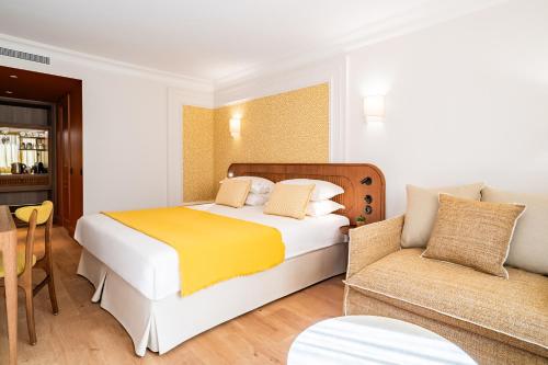 une chambre d'hôtel avec un lit et un canapé dans l'établissement Hôtel Lepoussin, à Cannes