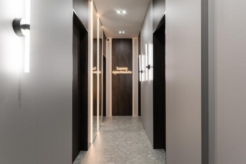 a hallway with white walls and black doors at EVURI Apartments BUDAPEST 2 in Uzhhorod