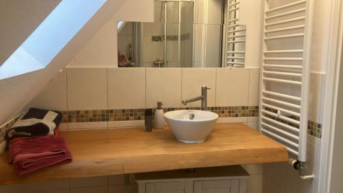a bathroom with a bowl sink on a wooden counter at Ferienwohnung Achelpöhler in Hagen im Bremischen