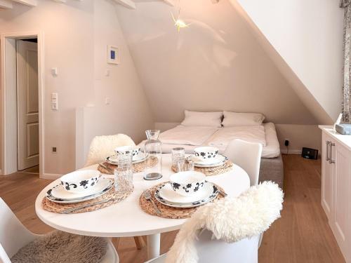 a white dining room with a table and chairs at Juwel in Keitum