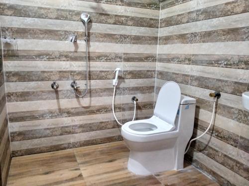 a bathroom with a toilet and a shower at Sandy Steps in Varkala