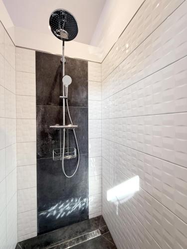 a shower in a bathroom with black and white tiles at Ferienwohnung-Karwe in Karwe