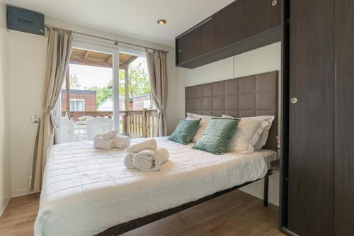 a bedroom with a large bed with towels on it at Club del Sole Spina Family Collection in Lido di Spina