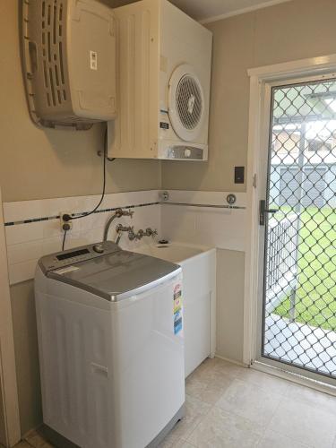a kitchen with a sink and a refrigerator at Bongaree Beach Shack - close to the bridge! in Bongaree