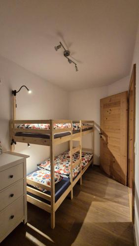 a bedroom with two bunk beds and a dresser at Ferienwohnung beim Schnellerbauer in Micheldorf in Oberösterreich