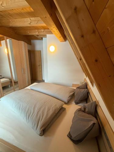 a large bed in a room with wooden ceilings at AusZeit in Gschnitz