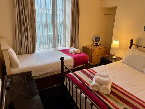 a hotel room with two beds and a window at Marine Apartment in Aberystwyth