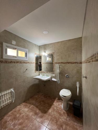 a bathroom with a toilet and a sink at Urunday Apart Hotel in Posadas