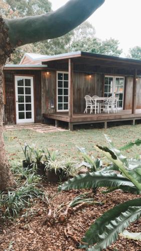 a small house with a table and chairs in front of it at Luxe Country Cabin - The Ateliers Cottage