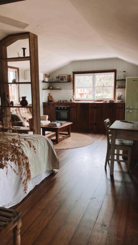 a room with a bed and a table and a kitchen at Luxe Country Cabin - The Ateliers Cottage
