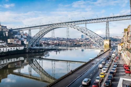 a train crossing a bridge over a river at Oporto Trendy River in Porto
