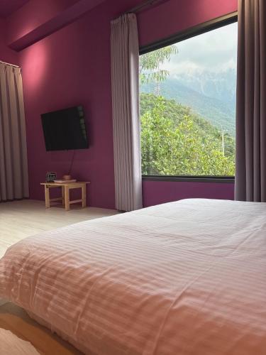 a bedroom with a large bed and a large window at 陌野輕旅民宿 in Xiulin