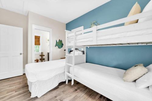 a bedroom with two bunk beds and a blue wall at Blue Sky Bungalow 156 in Seagrove Beach