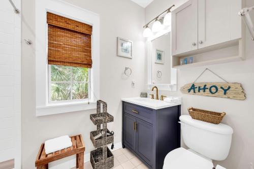 a bathroom with a toilet and a sink and a window at Blue Sky Bungalow 156 in Seagrove Beach