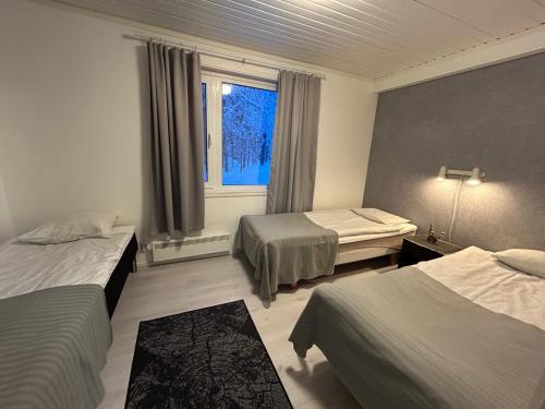 ein Hotelzimmer mit zwei Betten und einem Fenster in der Unterkunft Hotel Yöpuu in Kemi