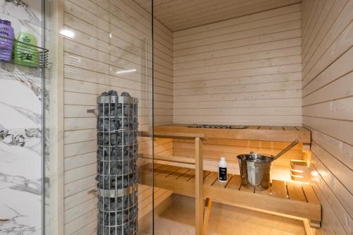 a sauna with a wooden bench and a shower at Lapland Apartment in Rovaniemi