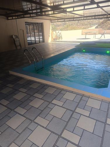 a swimming pool in a building with a tile floor at Dareen Resort 1 in Bahlāʼ