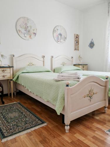 a bedroom with a white bed with a green comforter at B&B Chiara in Limena