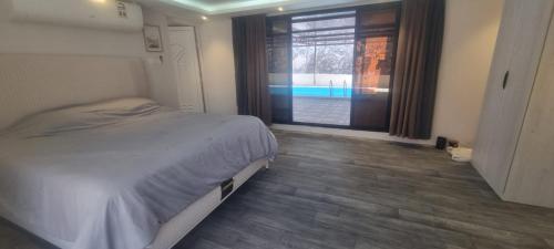 a bedroom with a bed and a view of a pool at Dareen Resort 1 in Bahlāʼ