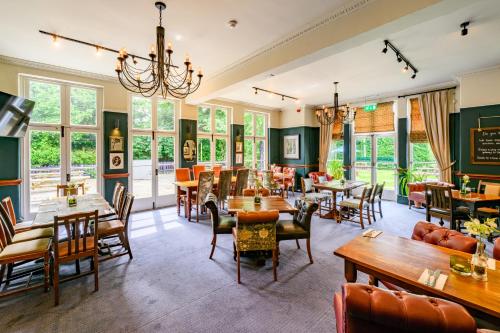 a restaurant with tables and chairs and windows at The Cheshire Cat by Innkeeper's Collection in Chester