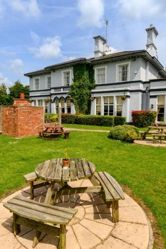 a picnic table in front of a large house at The Cheshire Cat by Innkeeper's Collection in Chester