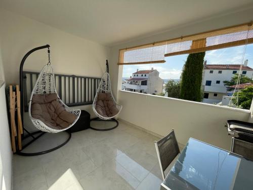 a balcony with two hanging hammocks and a window at Studio apartman Sunset cove in Stinica