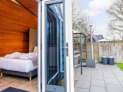 a glass door leading into a bedroom with a bed at Acorn Lodge At Bridge Lake Farm & Fishery in Banbury