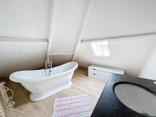a bathroom with a white bath tub and a sink at Le Napoléon in Compiègne