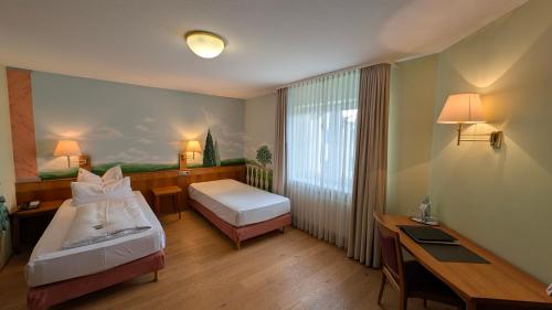 a hotel room with two beds and a desk at Hotel Restaurant Felix in Bensheim