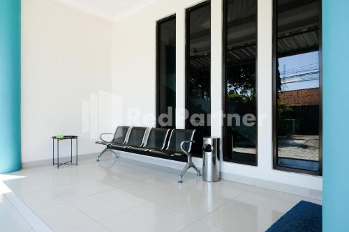 a bench in the middle of a room with windows at Hotel Andono near YIA Mitra RedDoorz in Yogyakarta