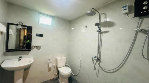 a bathroom with a shower and a toilet and a sink at Sigiriya Hidden Home Stay in Sigiriya