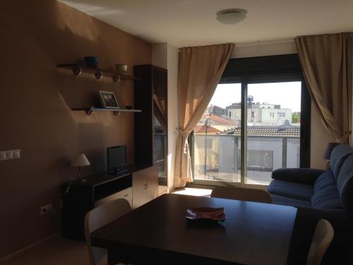a living room with a couch and a table and a window at Mi Apartamento en el Delta del Ebro in Deltebre