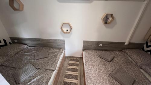 two twin beds in a room with two mirrors at Baba néni nyaralója in Szarvas