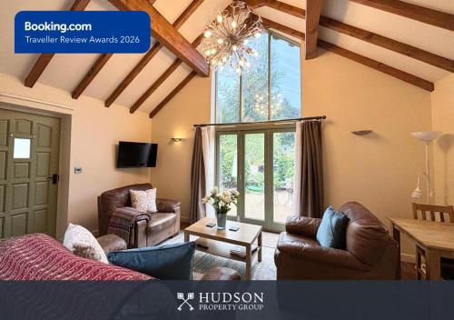 a living room with leather furniture and a large window at Beautiful Cottage in the Heart of Shrewsbury in Shrewsbury
