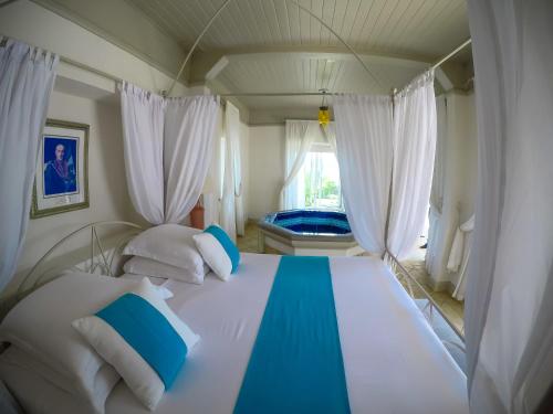 a bedroom with a large bed with white and blue pillows at Ile Des Deux Cocos in Blue Bay