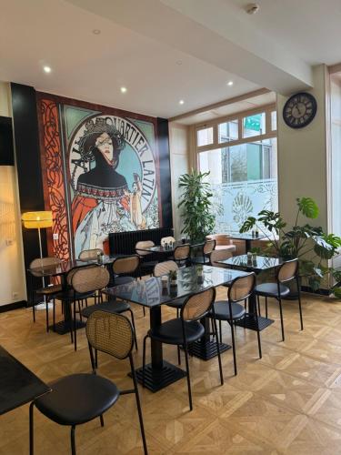 a restaurant with tables and chairs and a mural at Hôtel de la paix in Limoges