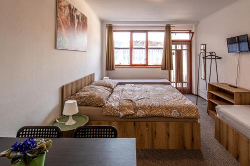 a bedroom with a bed and a table with chairs at K-plus penzión in Štúrovo