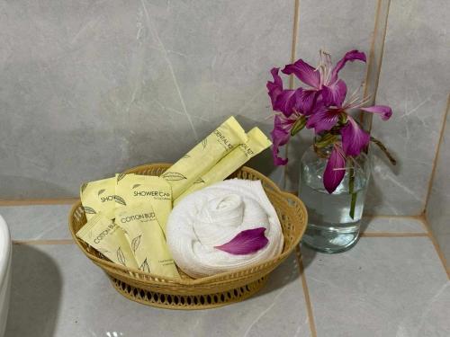a basket of towels and a vase with flowers at Tree Space Lanta Pool Stay Quiet & Near Beach in Ko Lanta