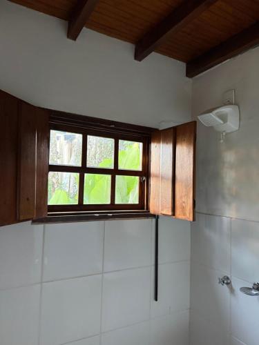 a bathroom with a window and a bath tub at Atelier-Aconchego e Fitness in Pirenópolis
