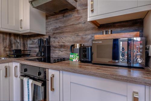a kitchen with white cabinets and a counter top at Artful flat with skyline view, Stokes Croft in Bristol