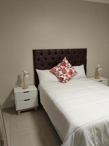 a bedroom with a bed with a pillow and a night stand at Indawo Guesthouse in Bloemfontein