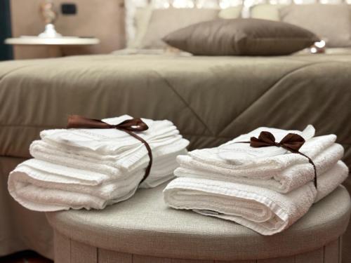 a pile of towels on a table next to a bed at La Dimora in Morino