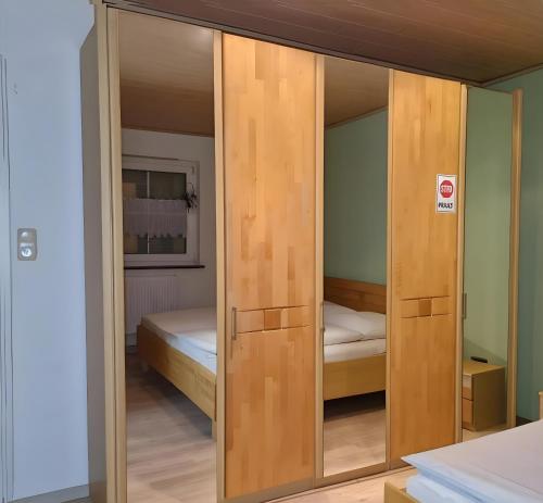 a wooden door in a room with a bed at Ferienwohnung Saller in Weißenbrunn