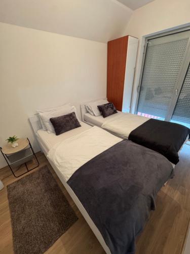 two beds sitting in a room with a window at Apartman Centar in Posušje
