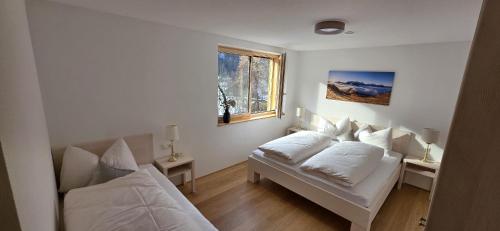 a white room with two beds and a window at Johler Appartements in Bezau