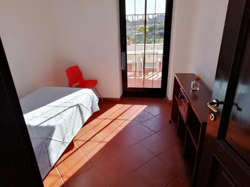 a bedroom with a bed and a red chair and a door at Antico Mulino in Imperia